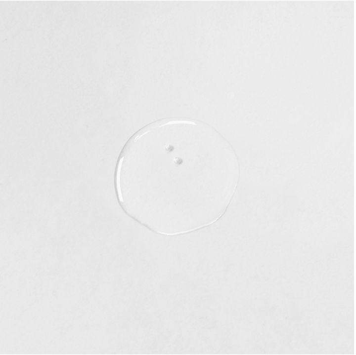 Heldere, ronde vloeistof op witte achtergrond. Twee kleine bellen zichtbaar.