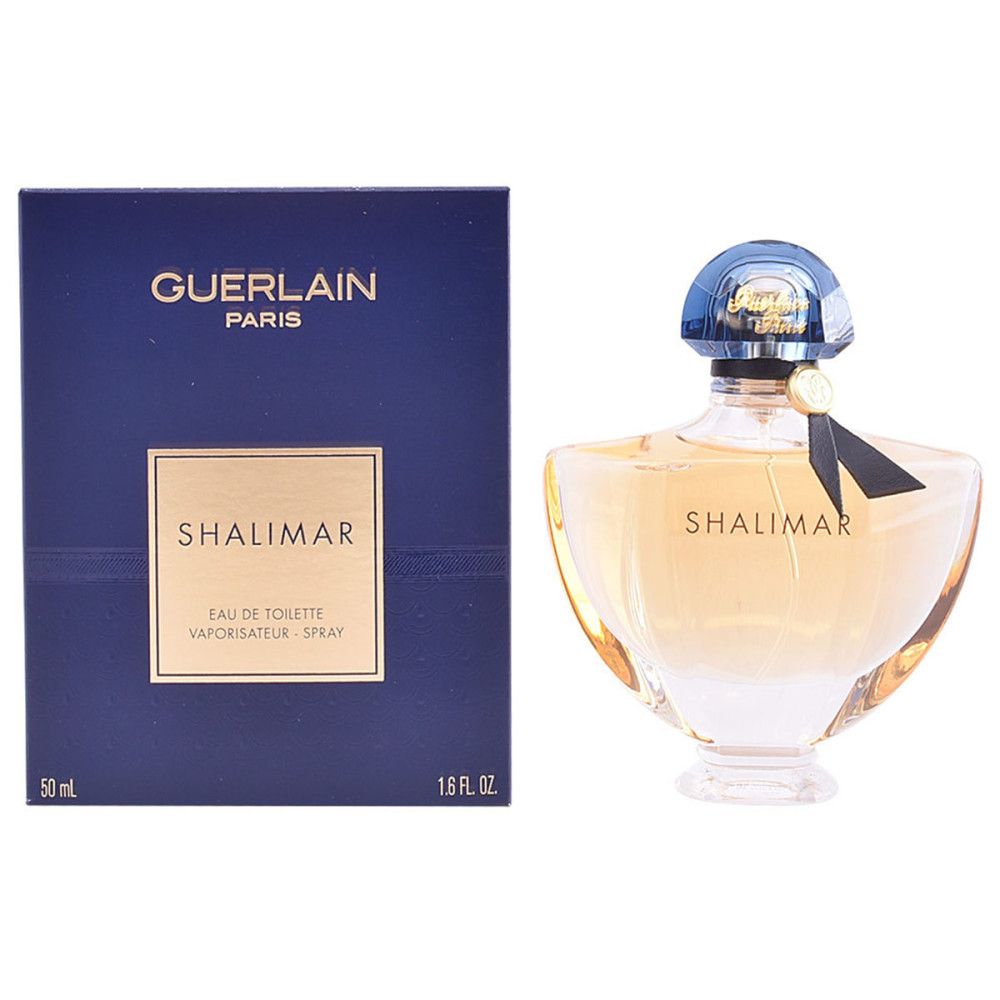 Flacon de parfum et emballage. Flacon avec bouchon bleu, étiquette dorée et ruban noir. Boîte bleue avec texte.