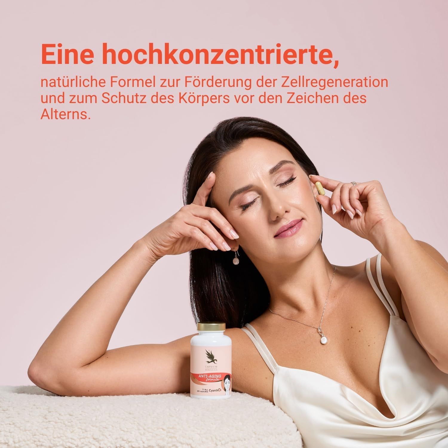 Vrouw houdt capsule en pilfles vast. Fles met gouden dop. Opschrift: Anti-Aging formula.