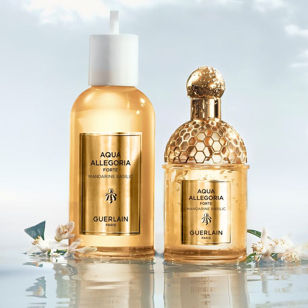 Twee flacons Guerlain Aqua Allegoria Forte. Gouden details, bijenlogo. Op water met bloemen.