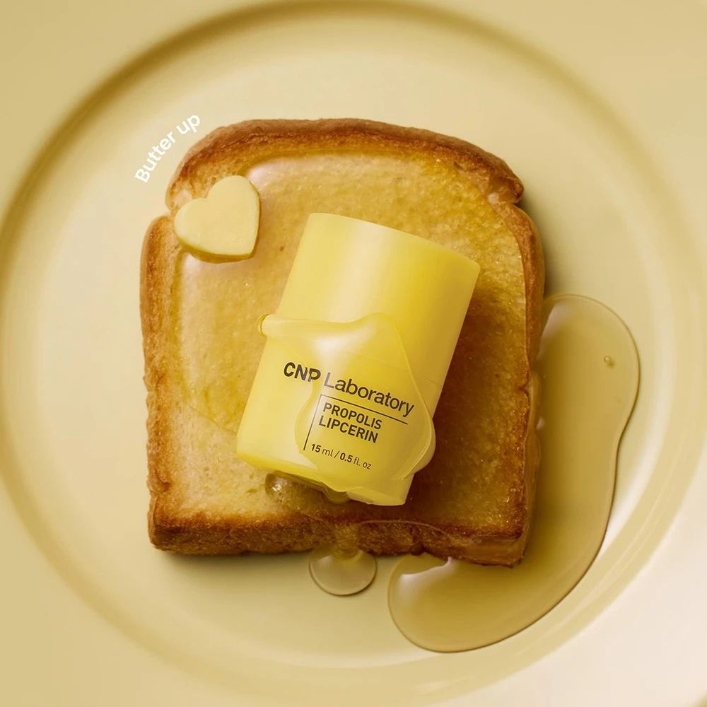 Gele CNP Laboratory Propolis Lippenmaske op toast met boter en honing.