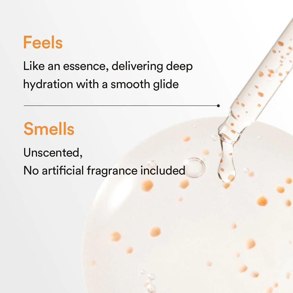 Een druppel helder serum met oranje deeltjes valt uit een pipet in een gladde, gelatineuze substantie.