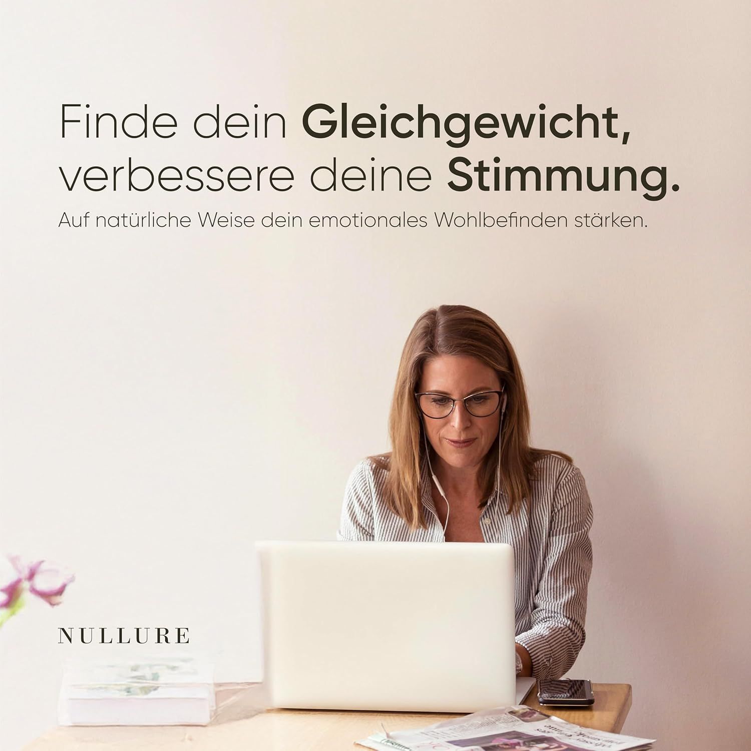 Femme à l'ordinateur portable, emballage Nullure sur la table. Texte : Trouvez votre équilibre, améliorez votre humeur.