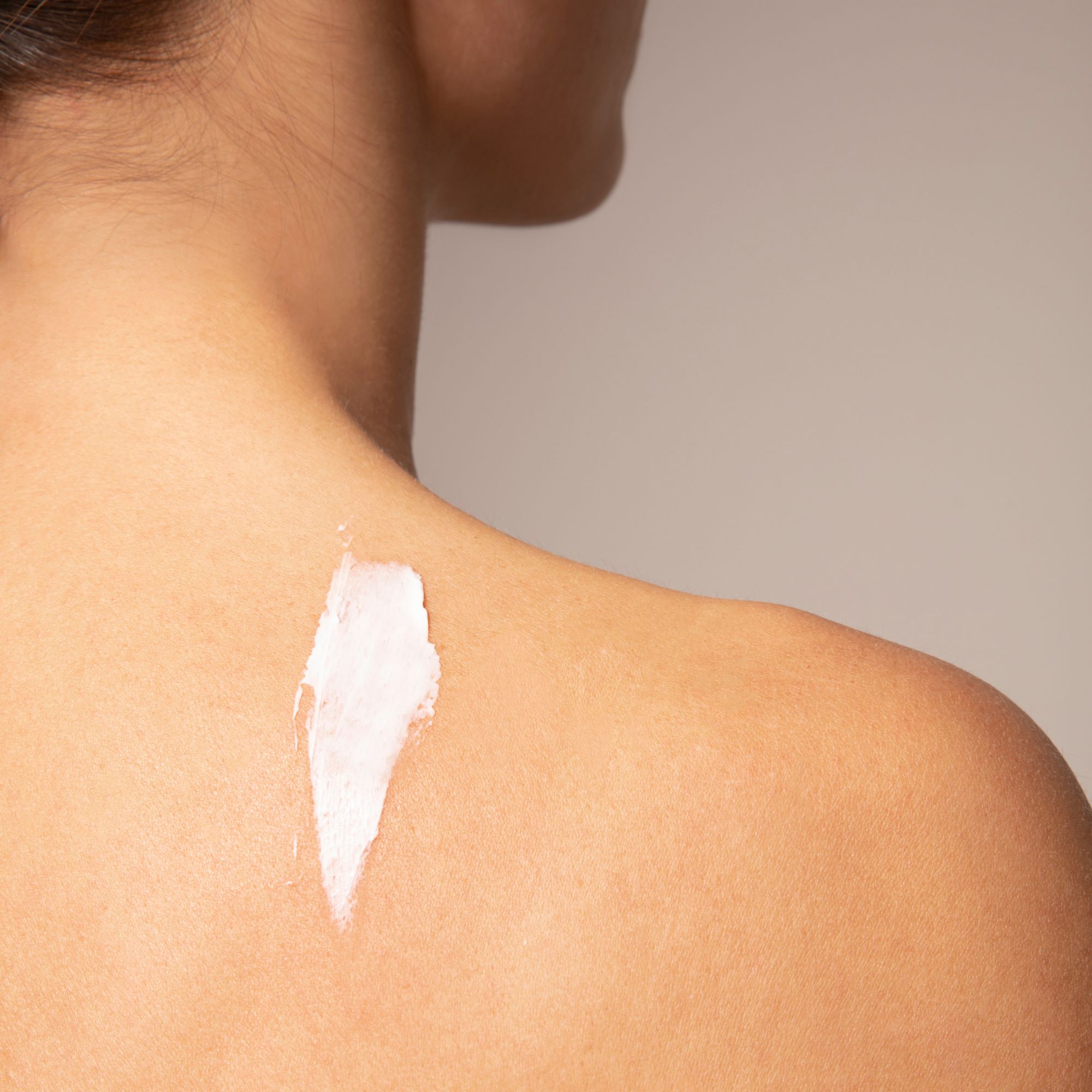 Une traînée de baume blanc sur la peau humaine, montrant la texture du produit.