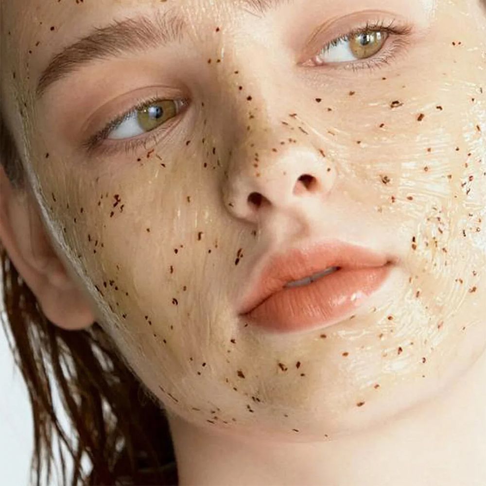Gros plan du visage d'une femme portant un masque facial gélatineux avec des grains.
