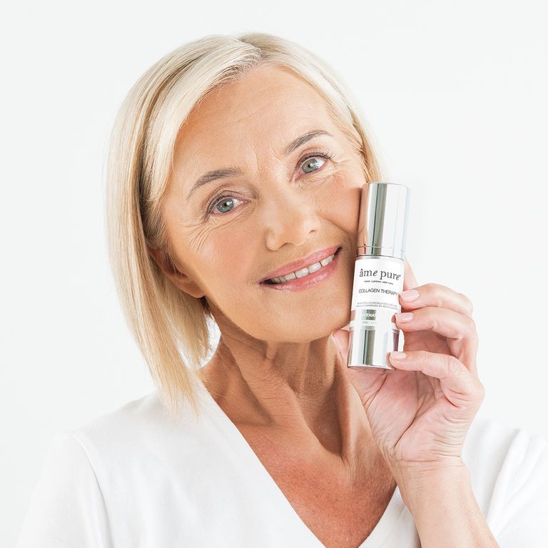 Lachende vrouw houdt een flesje Collagen Therapy Gel vast.