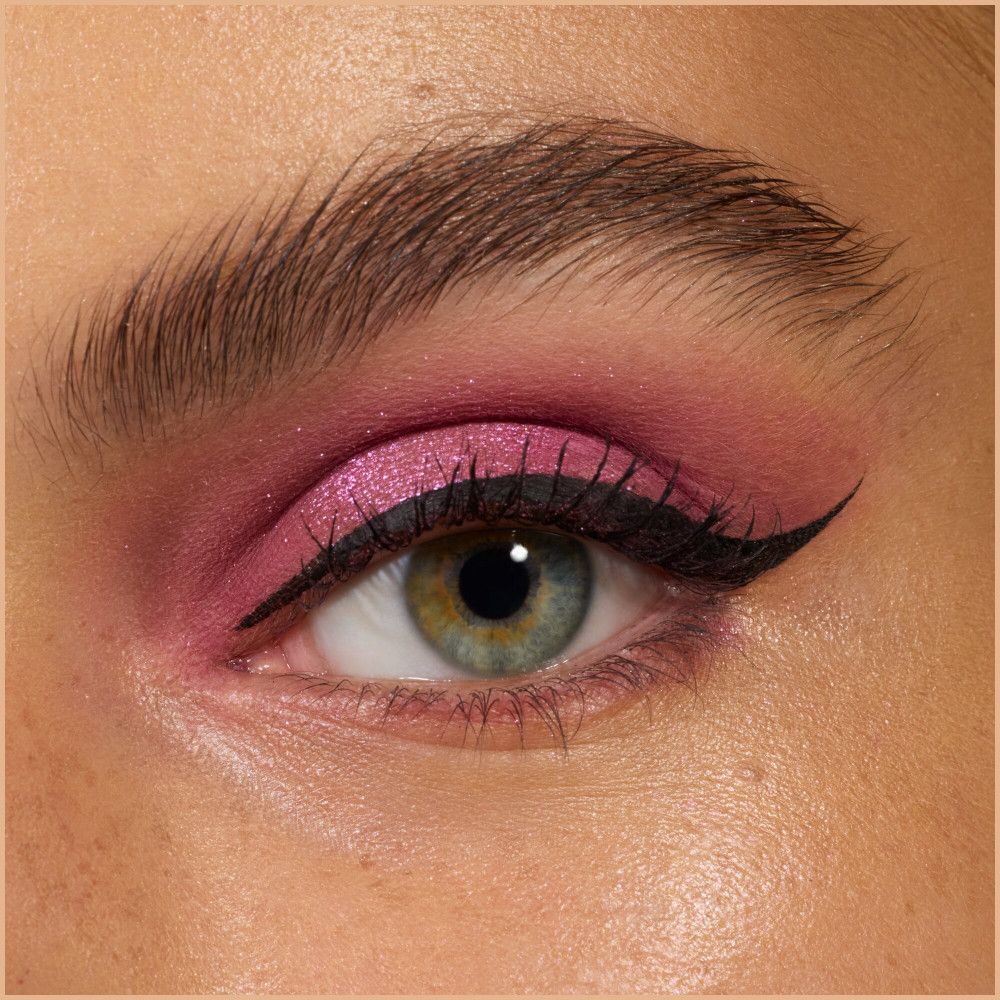 Gros plan sur un œil avec fard à paupières rose et eye-liner noir.