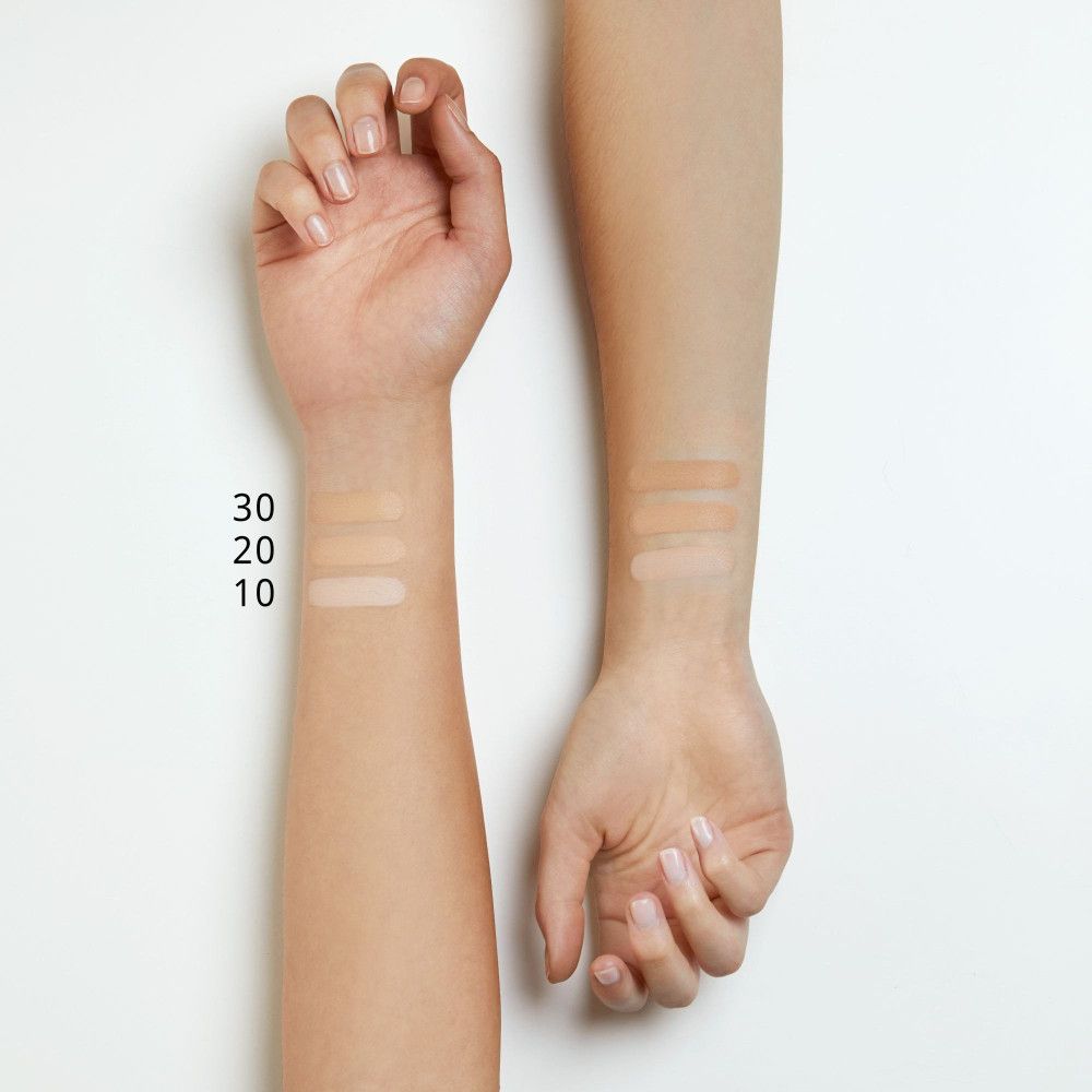 Bras avec trois couleurs de correcteur sur la peau. Numéros de couleur : 10, 20, 30. Teintes de peau. Sur fond blanc.