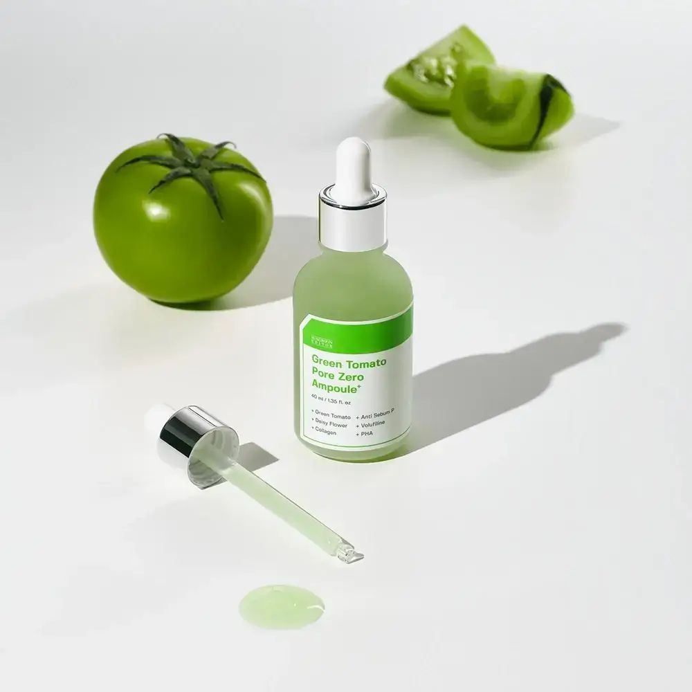 Groene fles met pipet en groene vloeistof. Groene tomaat en schijfjes. Opschrift: Green Tomato Pore Zero Ampoule+.
