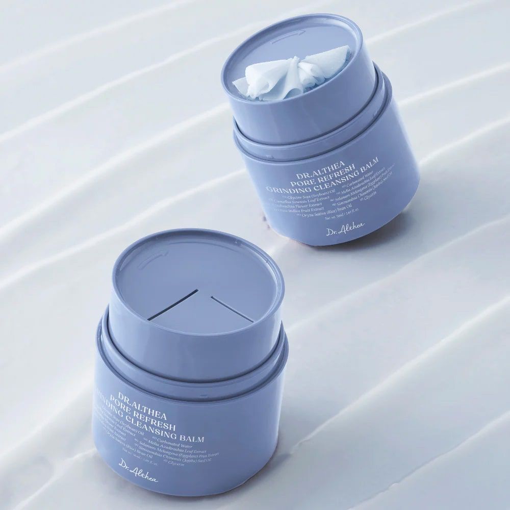 Deux contenants cylindriques bleus, un ouvert avec des lingettes. Inscription: DR.ALTHEA PORE REFRESH GRINDING CLEANSING BALM.