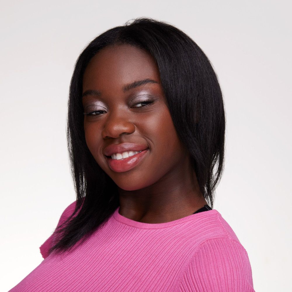 Portret van een jonge vrouw met een donkere huid, gekleed in roze en met oogschaduw.