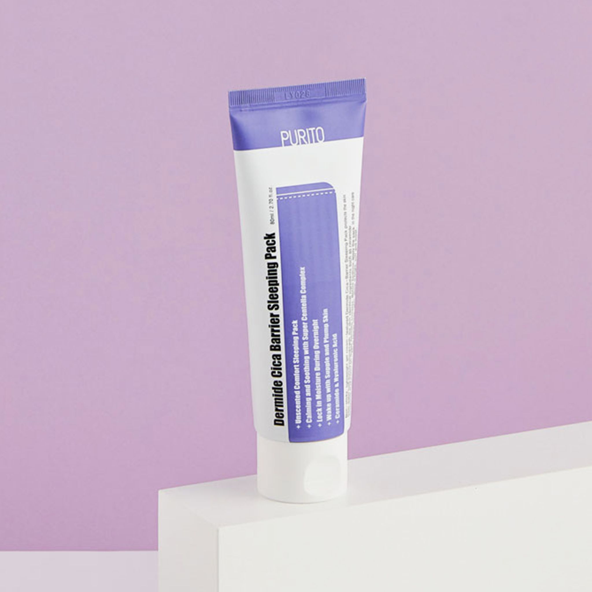 Witte en paarse tube op wit voetstuk. Merk PURITO. Tekst: Dermide Cica Barrier Sleeping Pack. Paarse achtergrond.