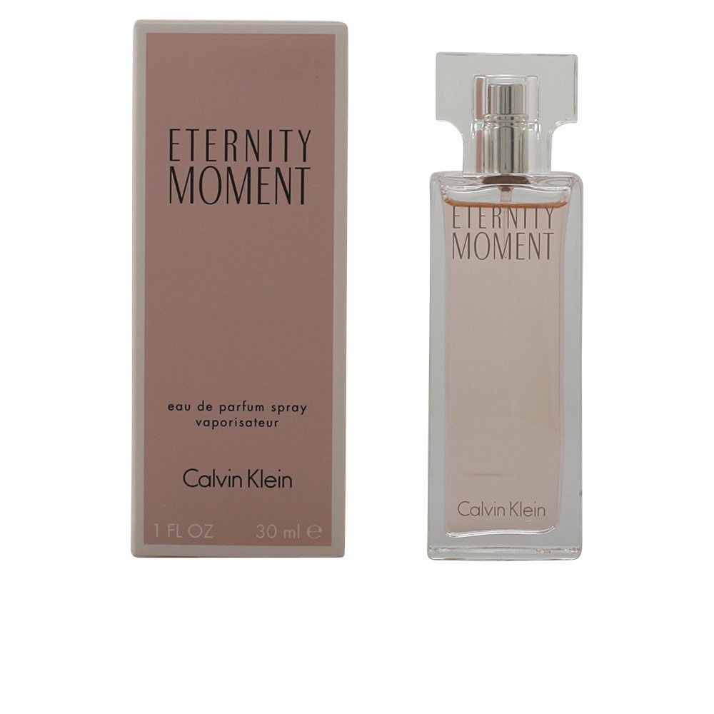 Flacon de parfum et boîte. Inscription : Eternity Moment. Flacon avec vaporisateur. Liquide rose. Calvin Klein.