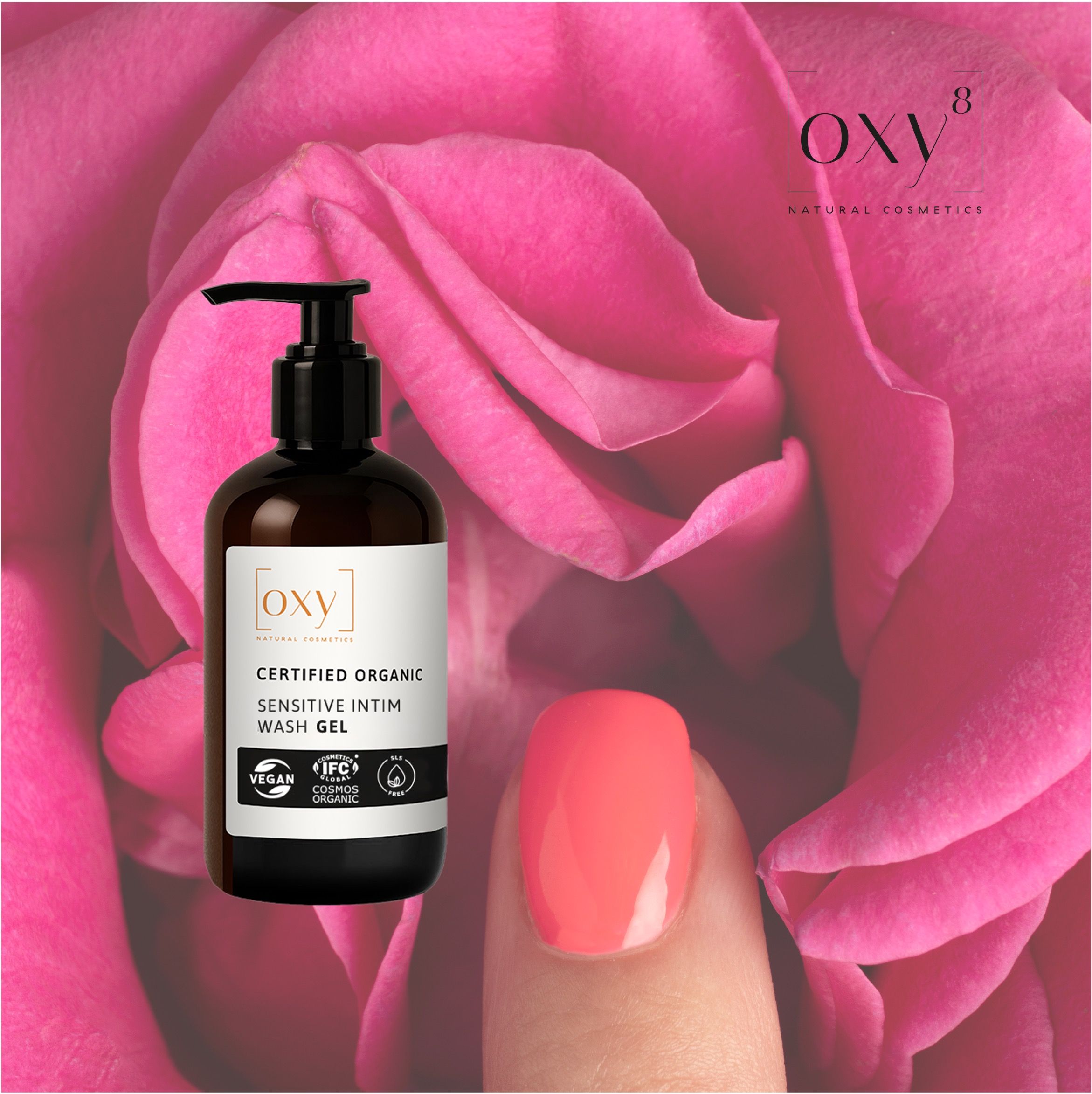 Bruine fles met pomp voor roze rozen. Opschrift: SENSITIVE INTIM WASH GEL. Logo's: Vegan, IFC Cosmos Organic. Geverfde nagel.