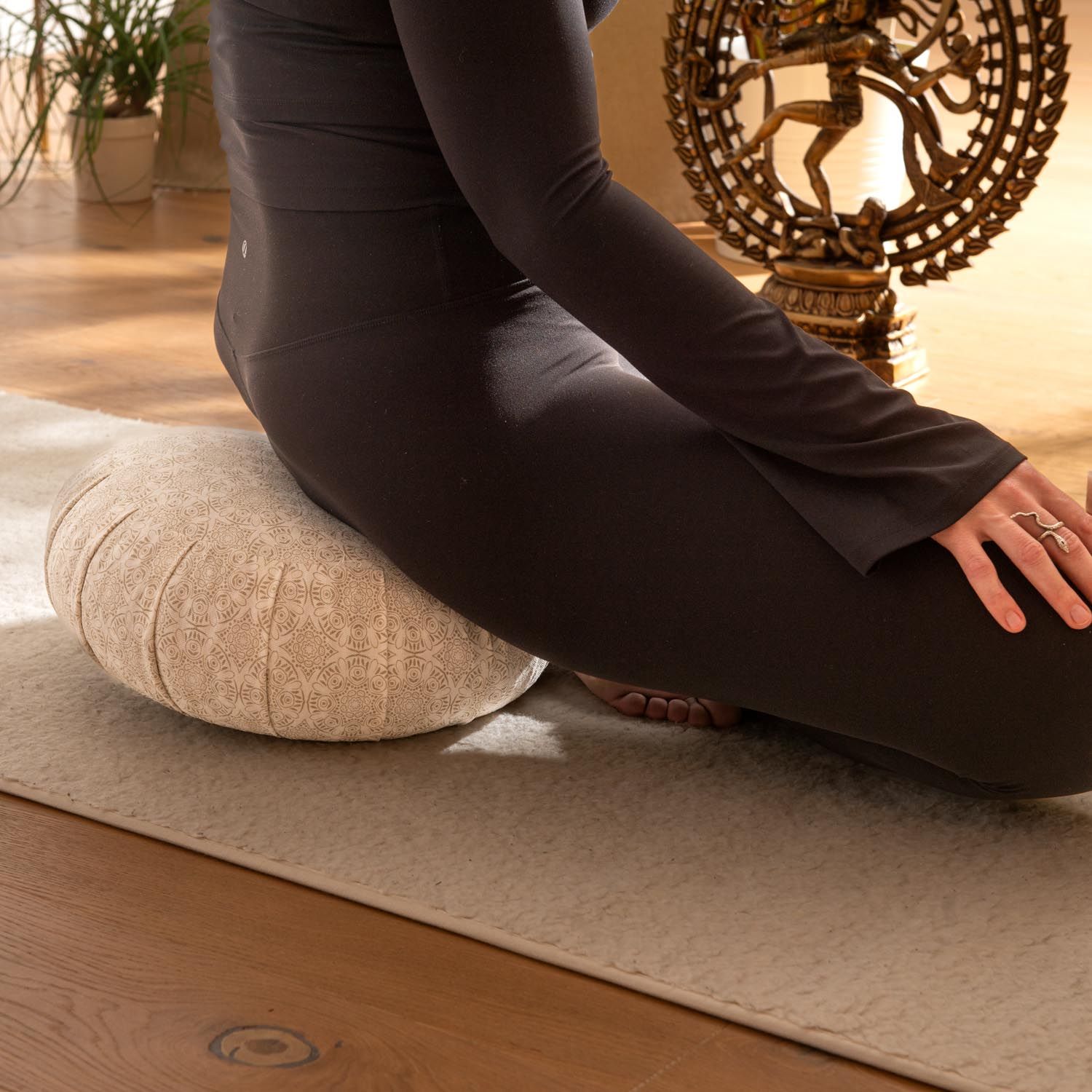 Coussin de méditation Bodhi Zafu avec motif, utilisé par une personne assise.