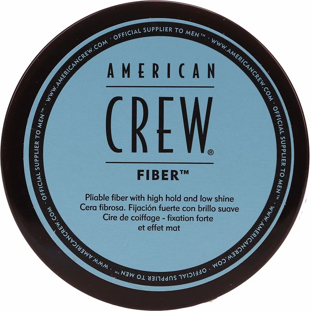 Donkerblauwe pot met "AMERICAN CREW FIBER". Tekst in het Engels, Spaans en Frans.