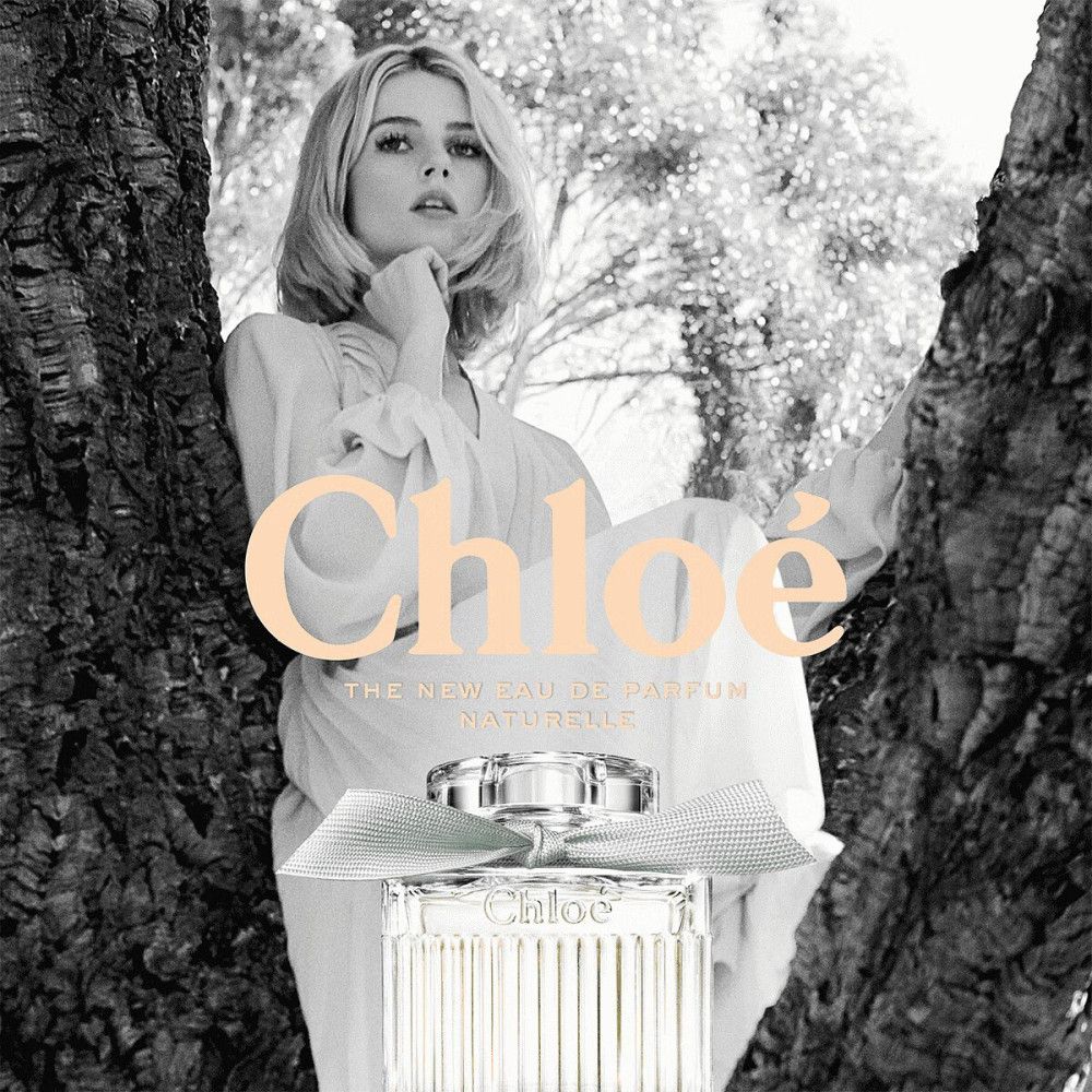 Zwart-witfoto van een vrouw tussen bomen. "Chloé" boven de fles.