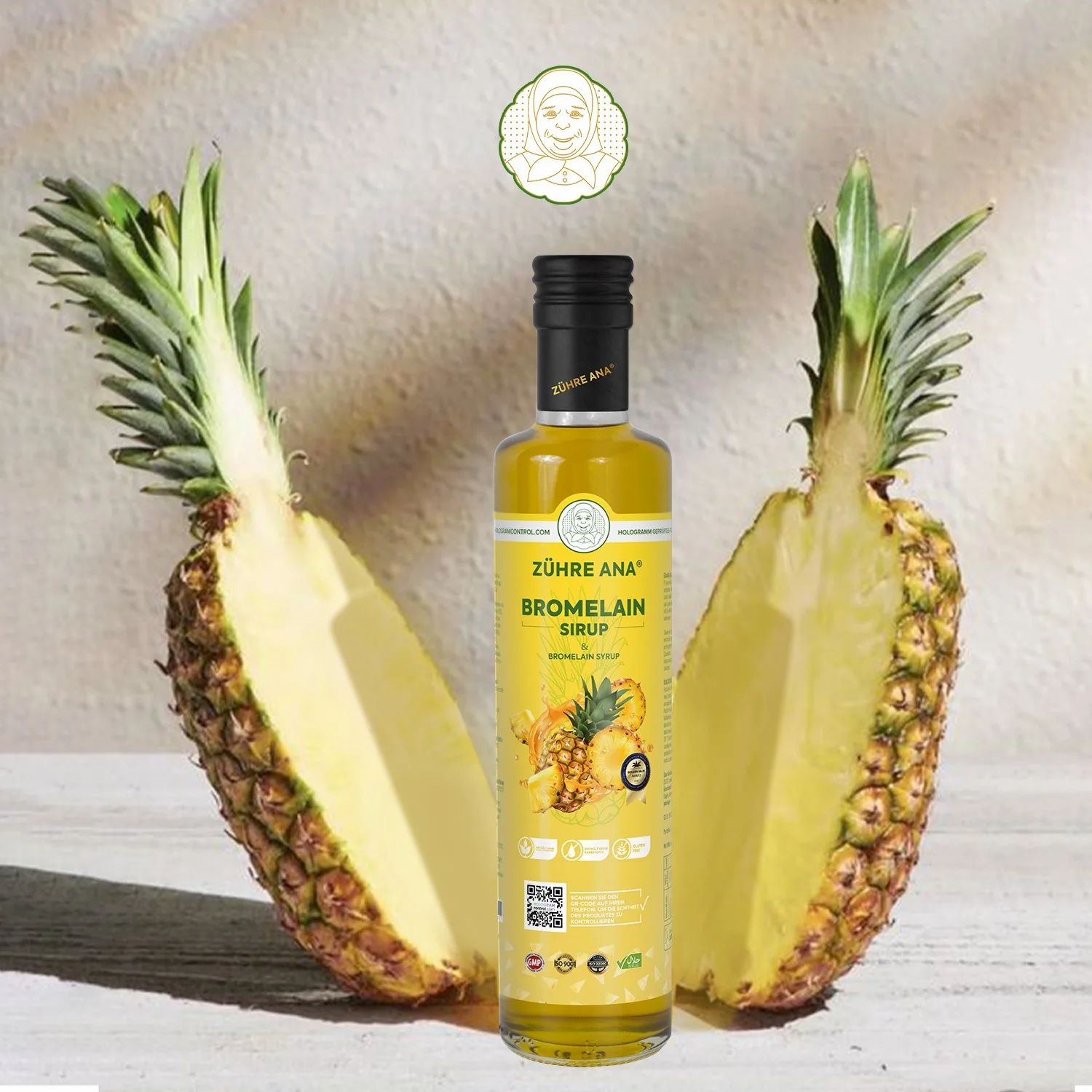Bouteille jaune avec bouchon noir. Inscription: Zühre Ana Bromelain Sirop. À côté, un ananas coupé en deux.