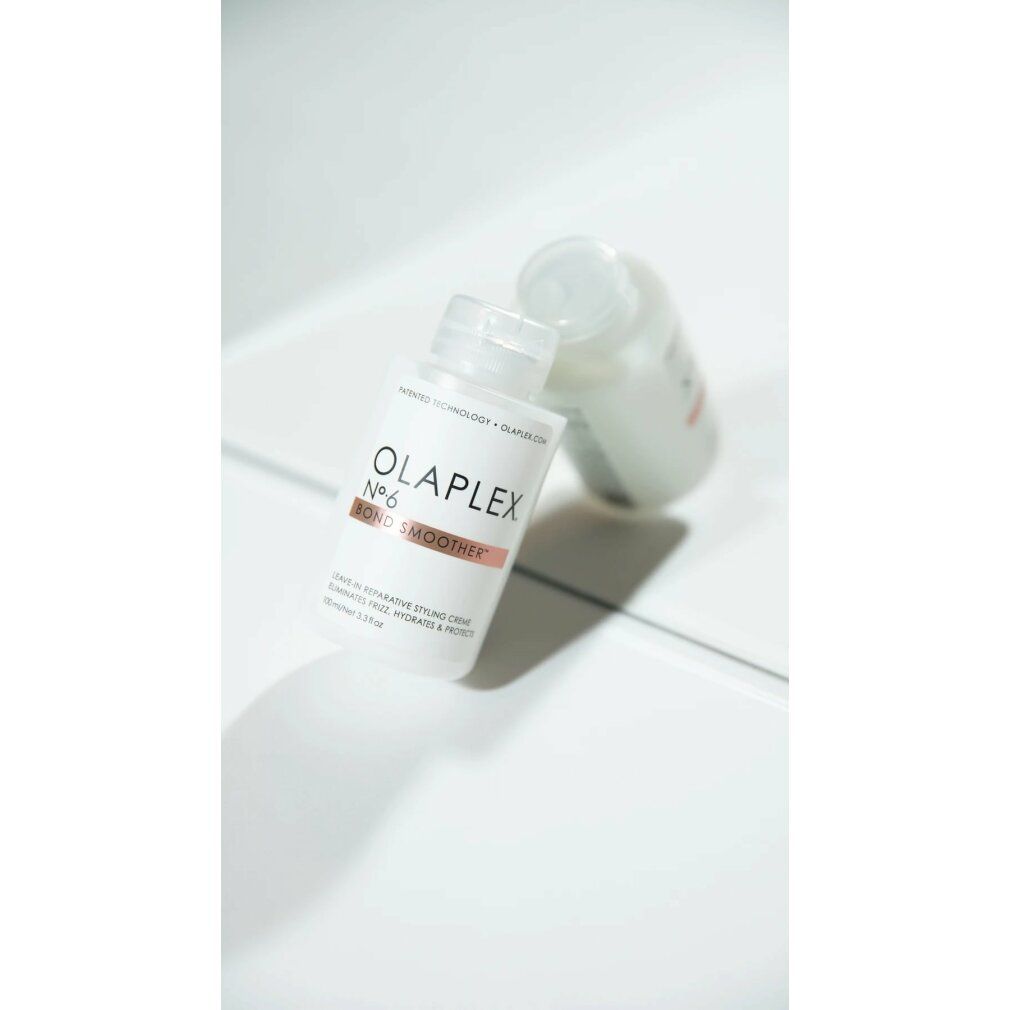 Deux flacons blancs Olaplex No.6 Bond Smoother. Bande marron avec texte. Sur surface blanche.