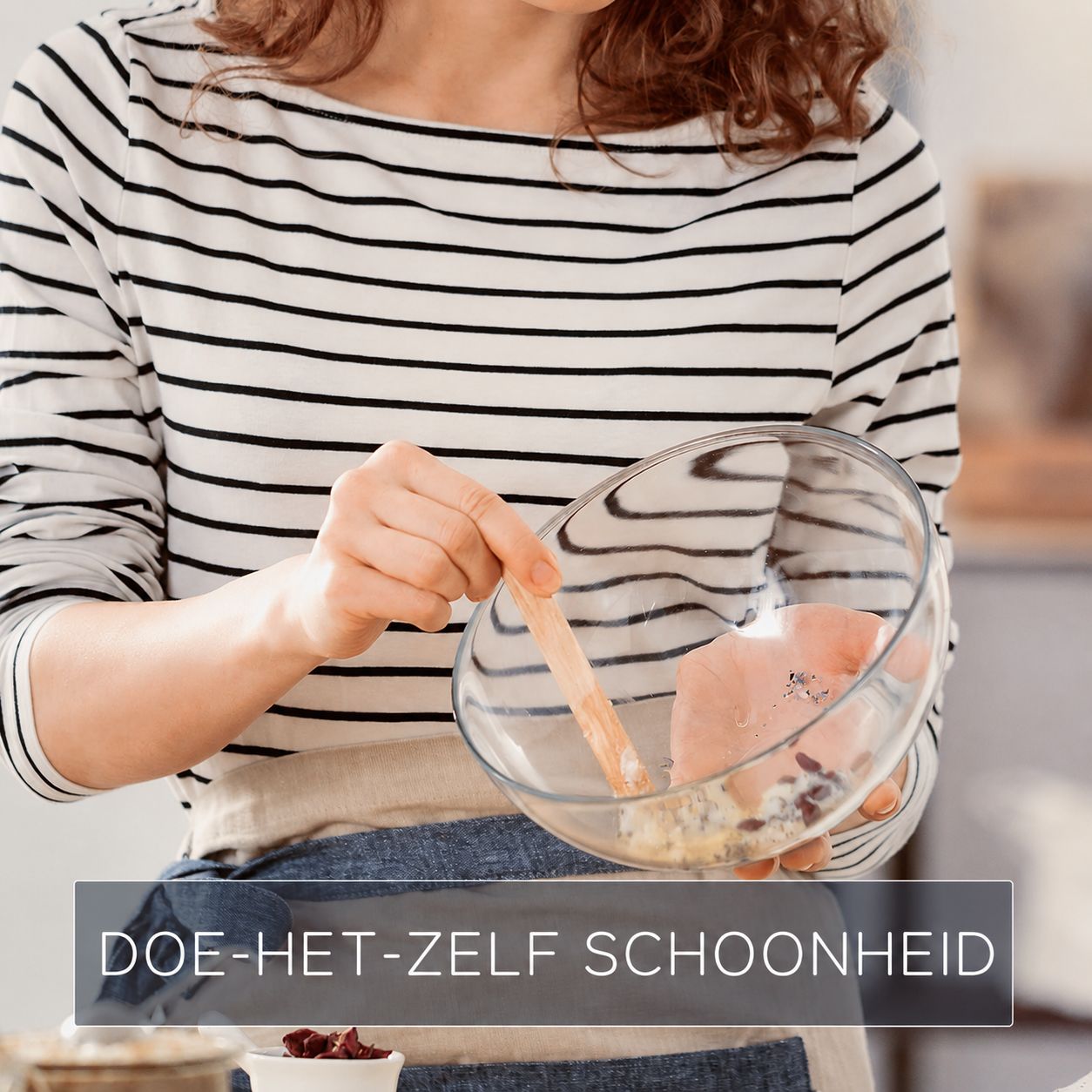 Een persoon mengt ingrediënten in een glazen kom met een houten spatel.