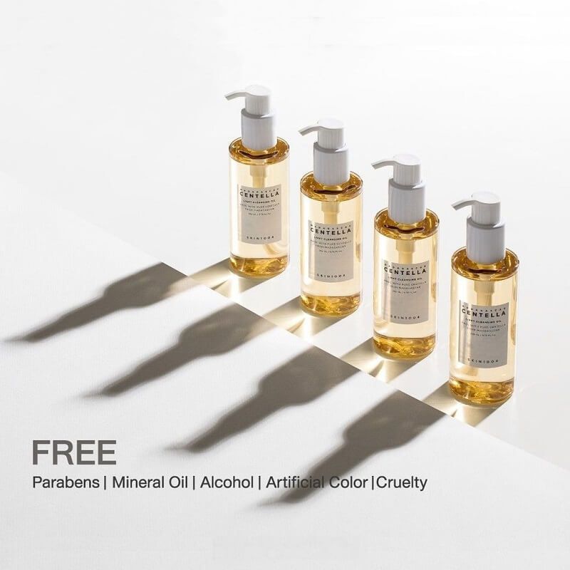 Quatre flacons avec pompe. Étiquette : Madagascar Centella Light Cleansing Oil. Marque : SKIN1004. Ombres sur fond blanc. Texte : FREE.