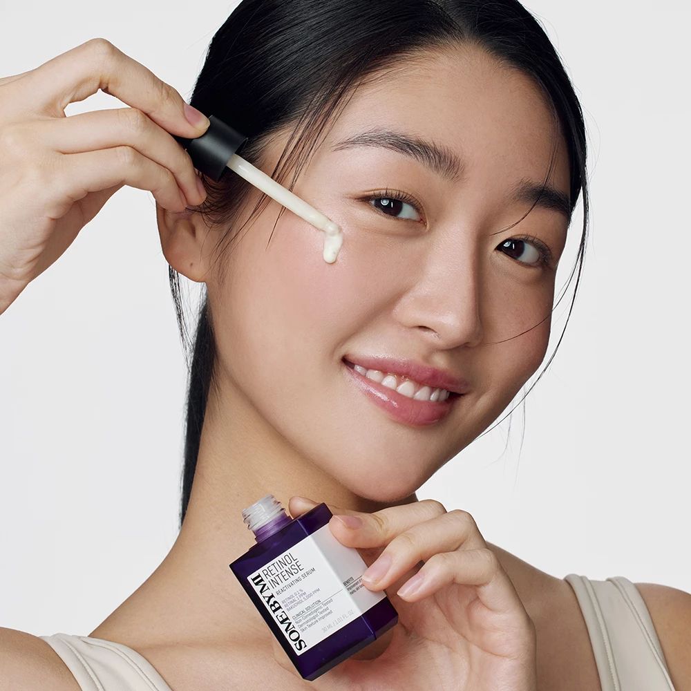 Femme avec flacon de sérum et applicateur. Nom du produit et texte visibles.