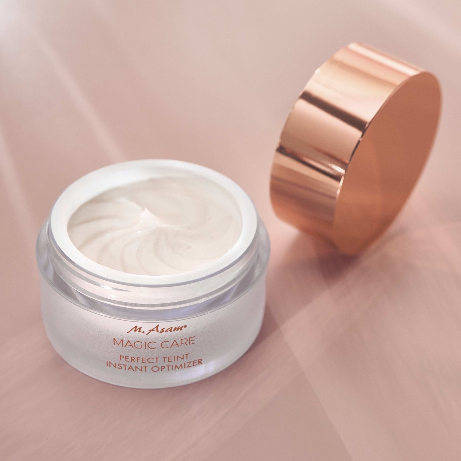 Crèmepot met open deksel. Tekst: M. Asam MAGIC CARE PERFECT TEINT INSTANT OPTIMIZER. Crème zichtbaar.