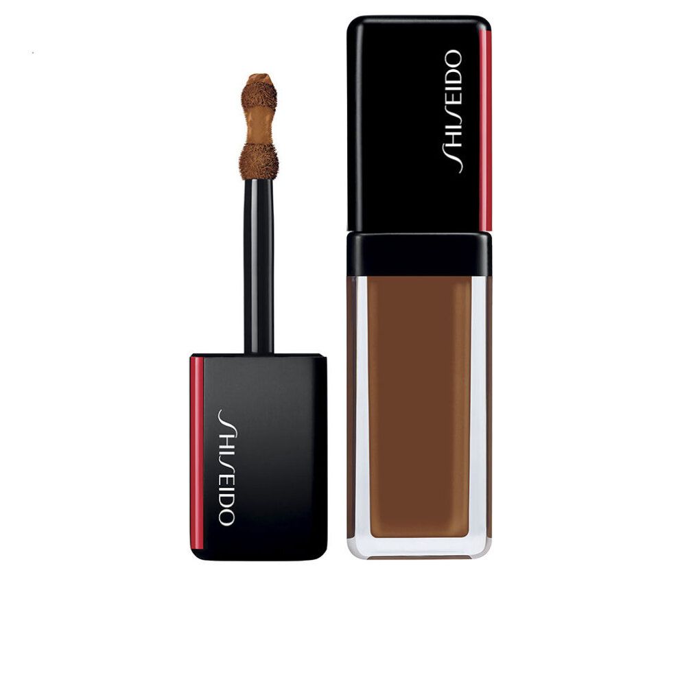 Correcteur Shiseido Synchro Skin. Liquide brun foncé en flacon rectangulaire. Bouchon noir avec accent rouge. Applicateur visible.