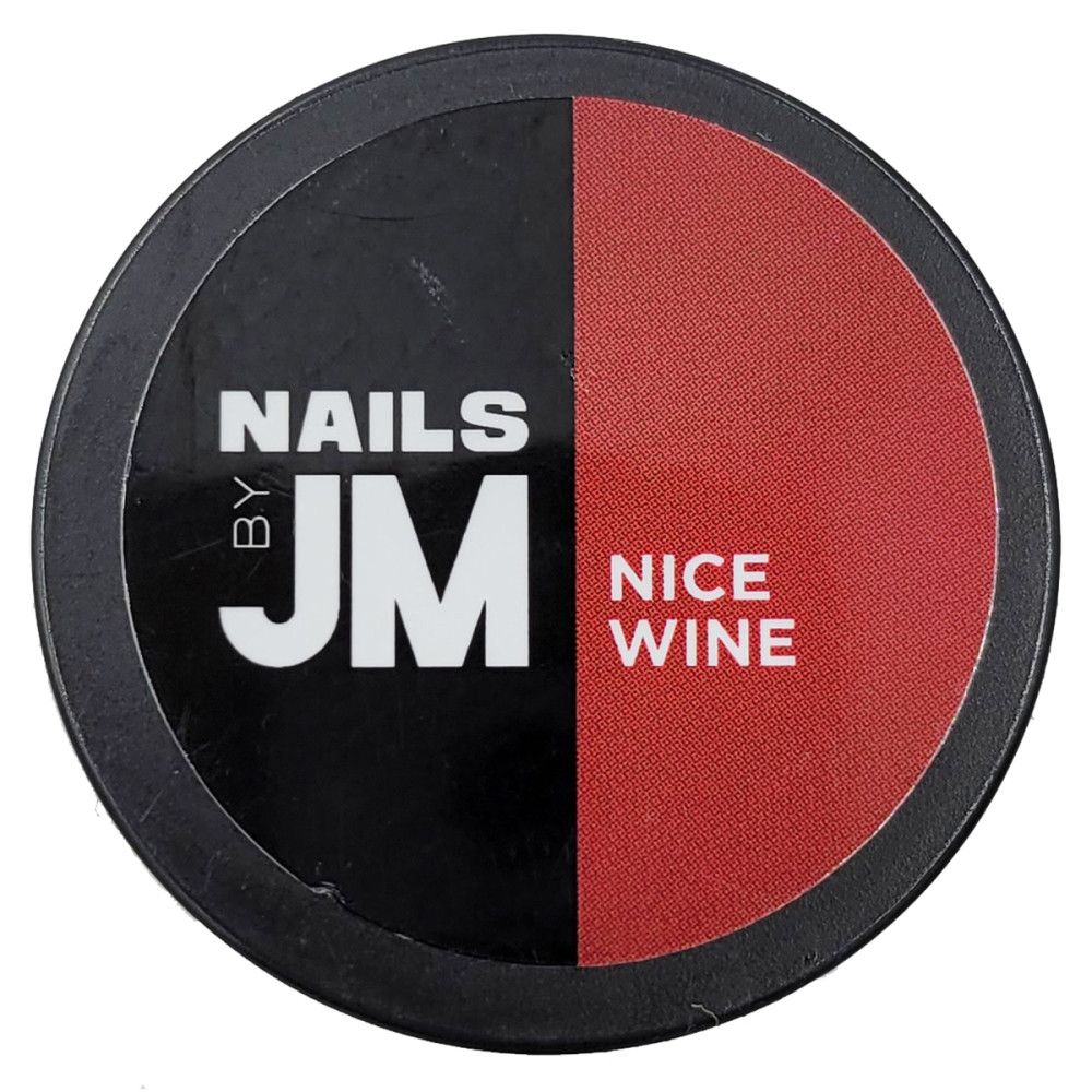 Contenant rond, divisé en noir et rouge. Sur le noir : "NAILS BY JM". Sur le rouge : "NICE WINE".