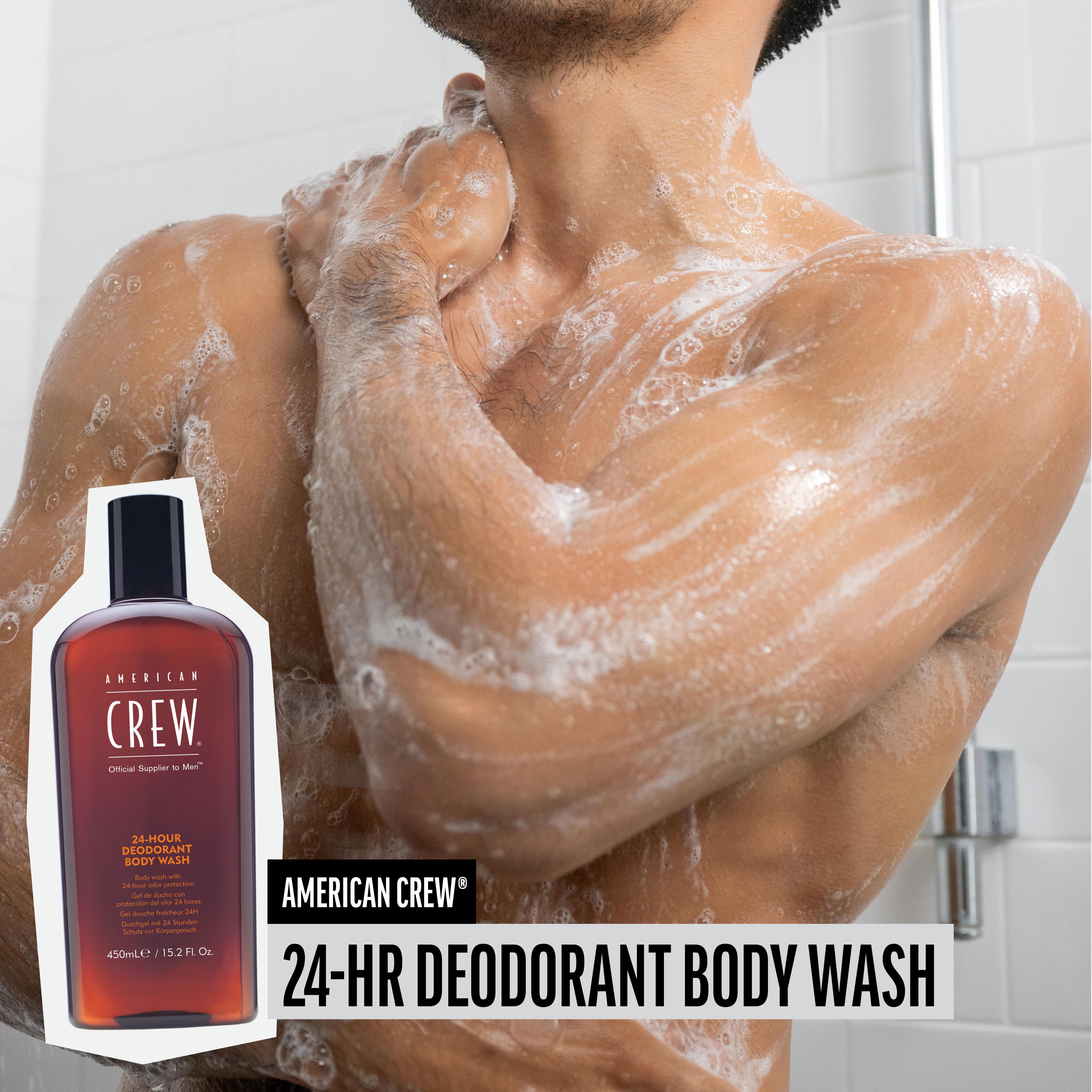 Man onder de douche. Naast hem: fles AMERICAN CREW 24-HR DEODORANT BODY WASH. Schuim op de huid.