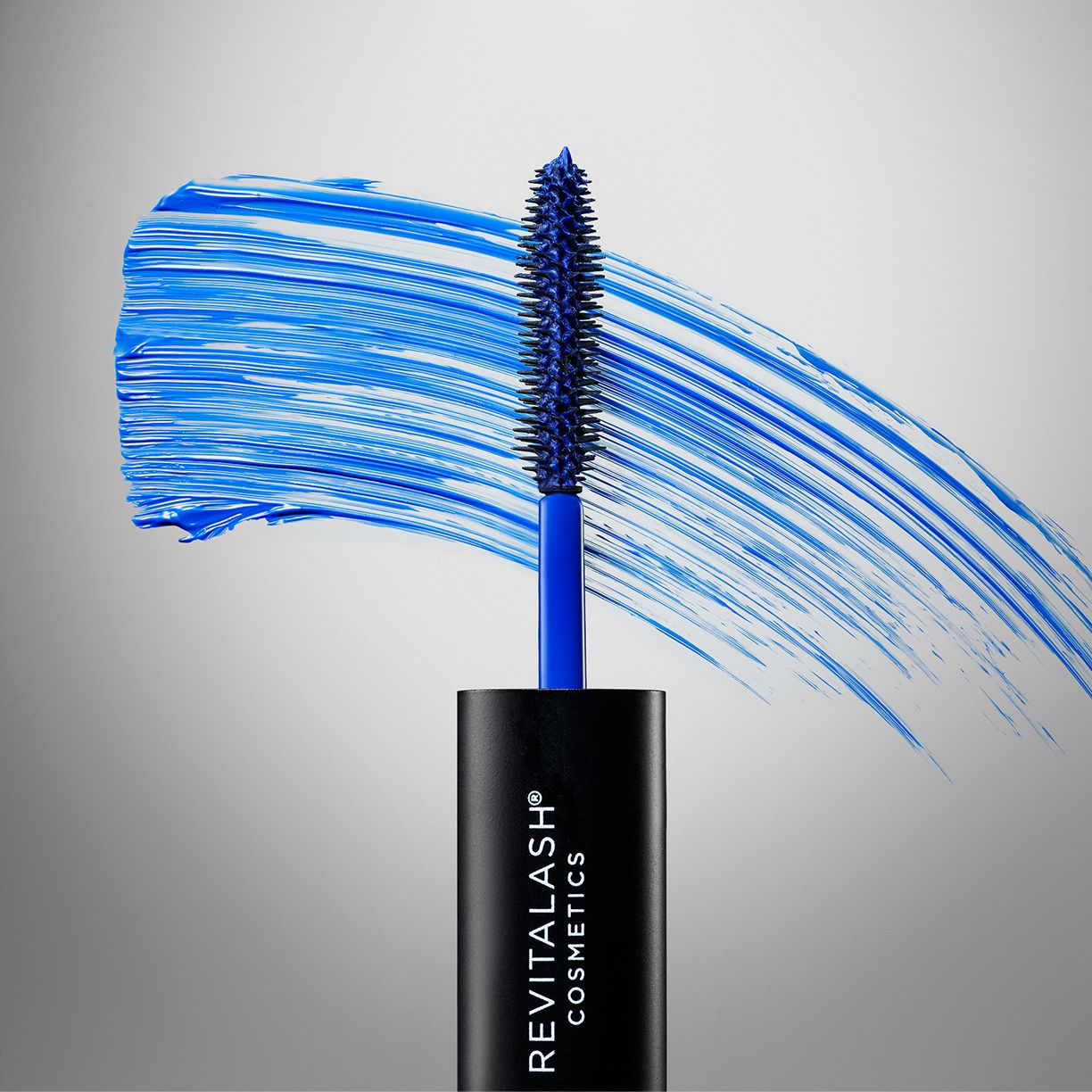Blauwe mascaraborstel met blauwe veeg op grijze achtergrond. RevitaLash Cosmetics logo.
