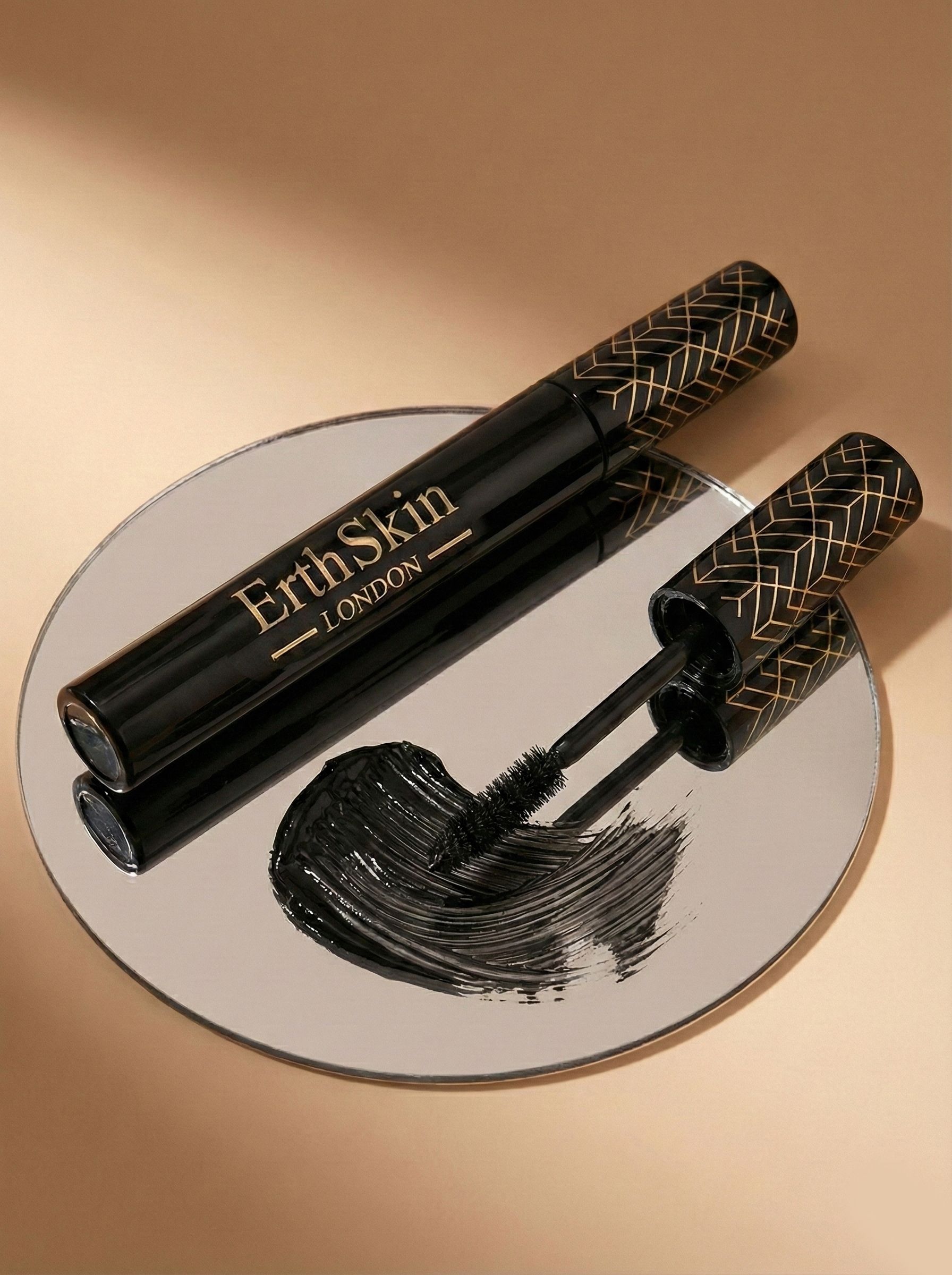 Zwarte mascara met gouden tekst 'ErthSkin LONDON' op een spiegel.