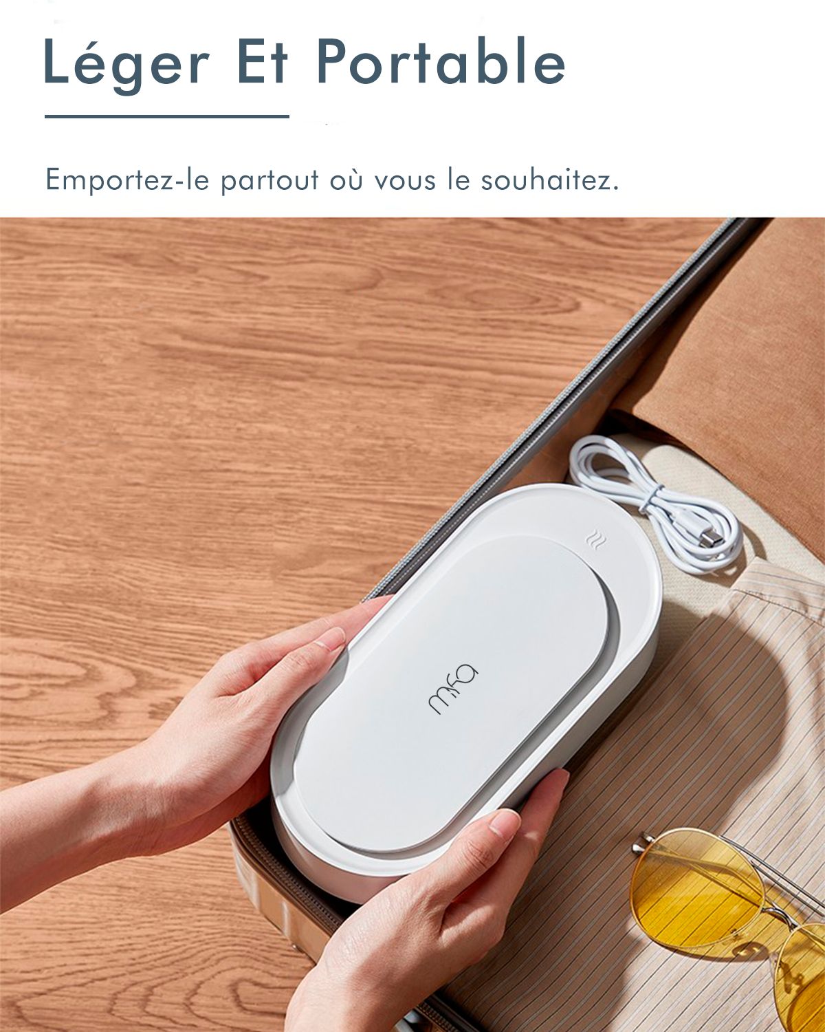 Personne tenant un nettoyeur à ultrasons blanc dans une valise. Lunettes de soleil jaunes.