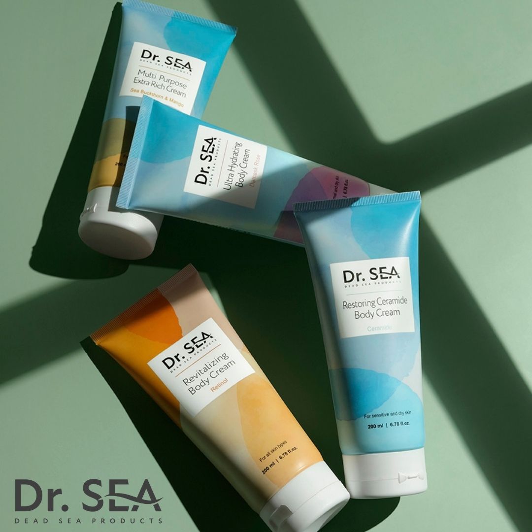Vier tubes DR. SEA bodycrème. Verschillende designs: Ultra Hydrating, Restoring Ceramide, Revitalizing Body Cream. Groene achtergrond.