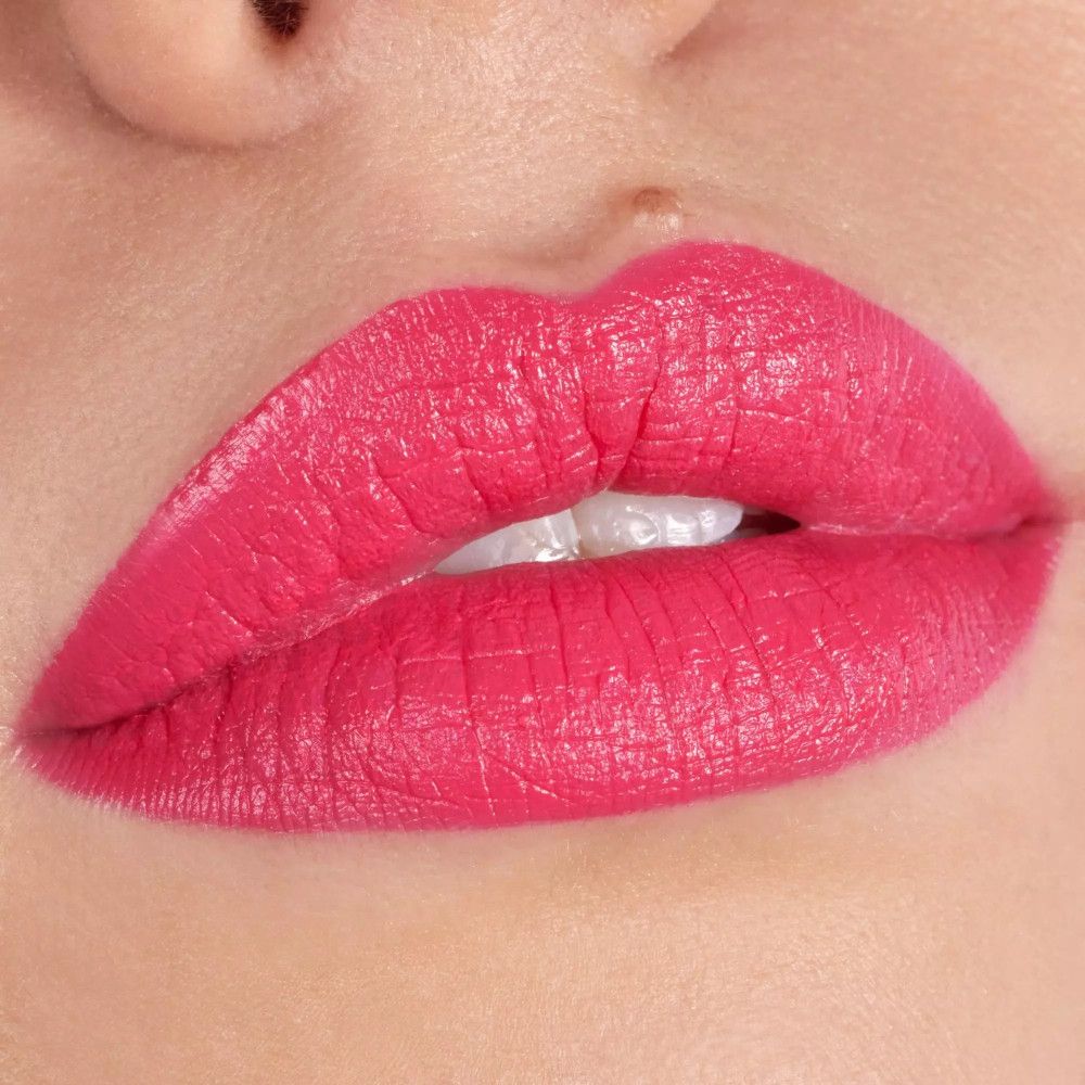 Gros plan sur des lèvres maquillées avec du rouge à lèvres rose. Les lèvres sont lisses et définies.