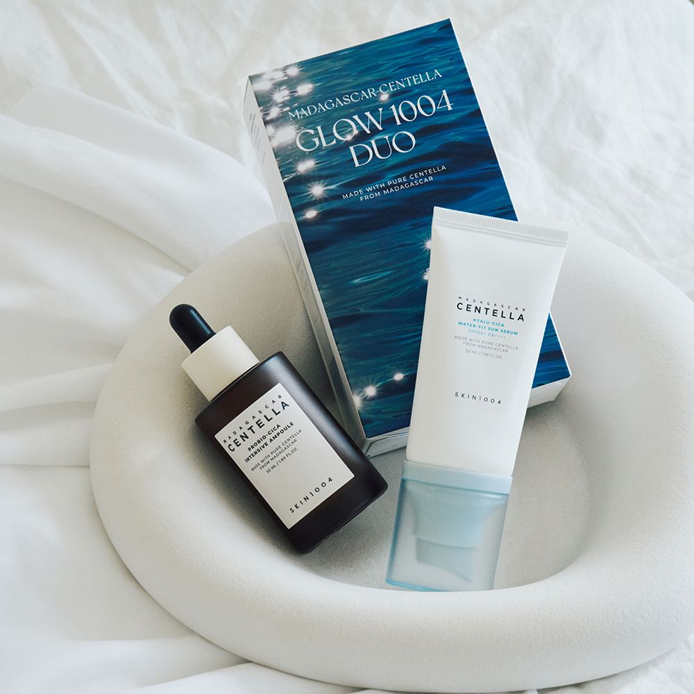 Duo-set met serum, ampul en verpakking. Op witte stof. Ampul en serum in flessen. Verpakking met blauw ontwerp.