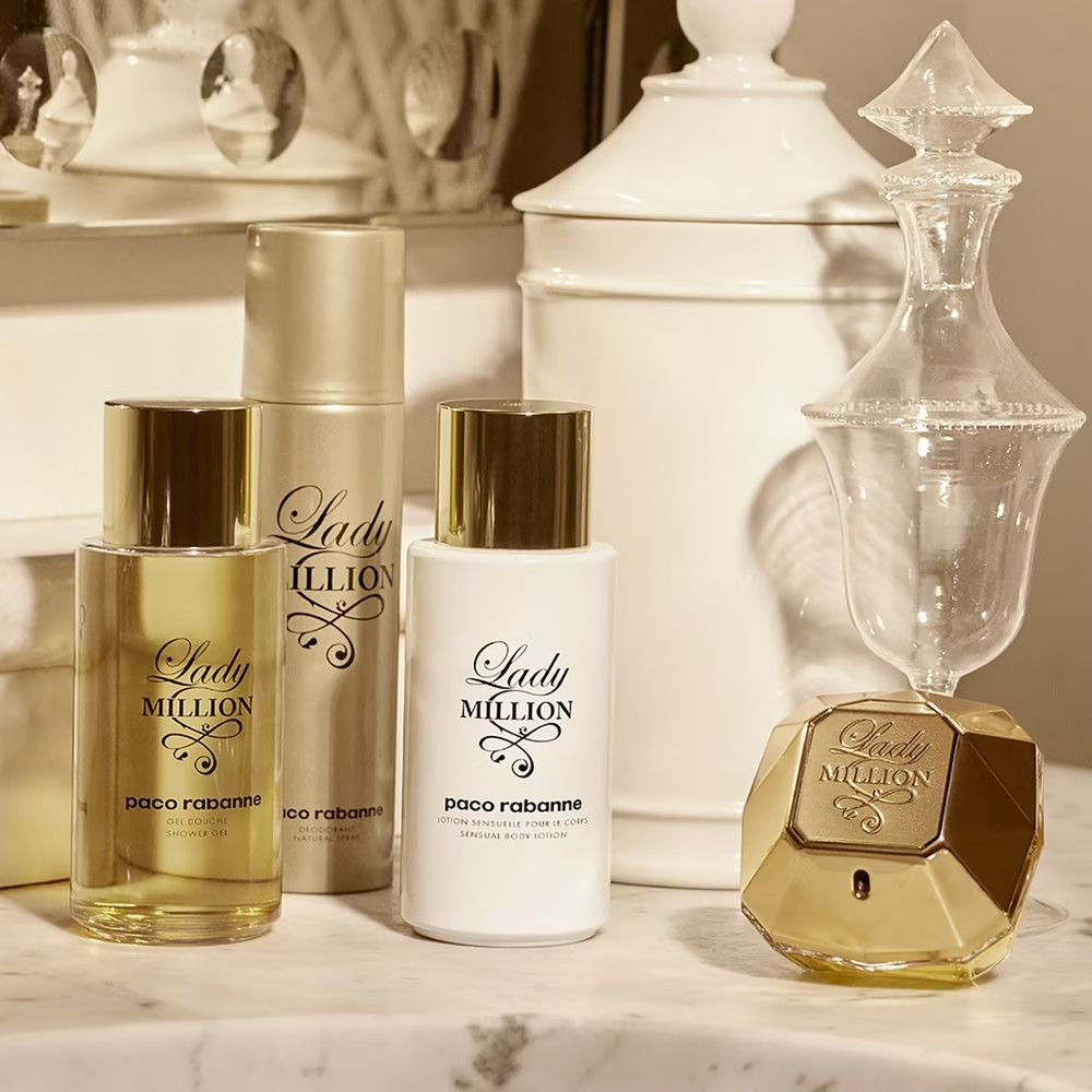 Produits Lady Million sur une surface. Flacon, lotion et spray. Flacon en forme de diamant. Fond blanc.