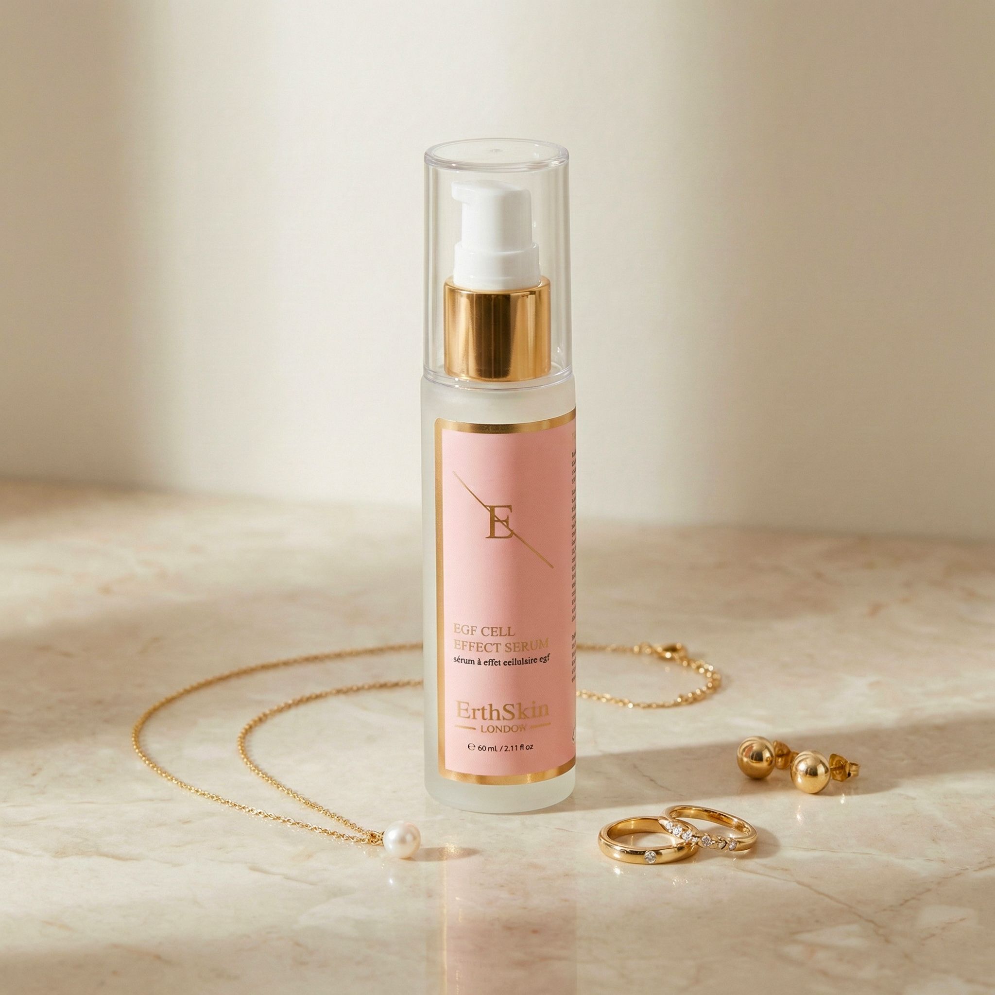 Sérum ErthSkin London EGF à côté de bijoux : collier, boucles d'oreilles et bagues sur surface en marbre.
