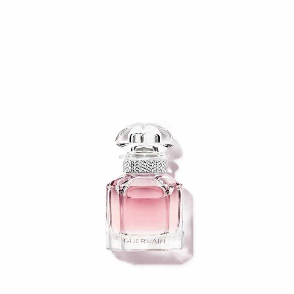 Kleine roze parfumfles met transparante dop en strass. Guerlain-logo op de voorkant.