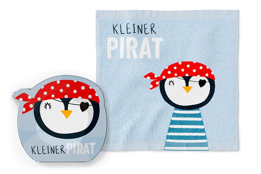 Lichtblauwe handdoek met pinguïn piratenmotief en opschrift "Kleiner Pirat". Daarnaast een bijpassende kaart.