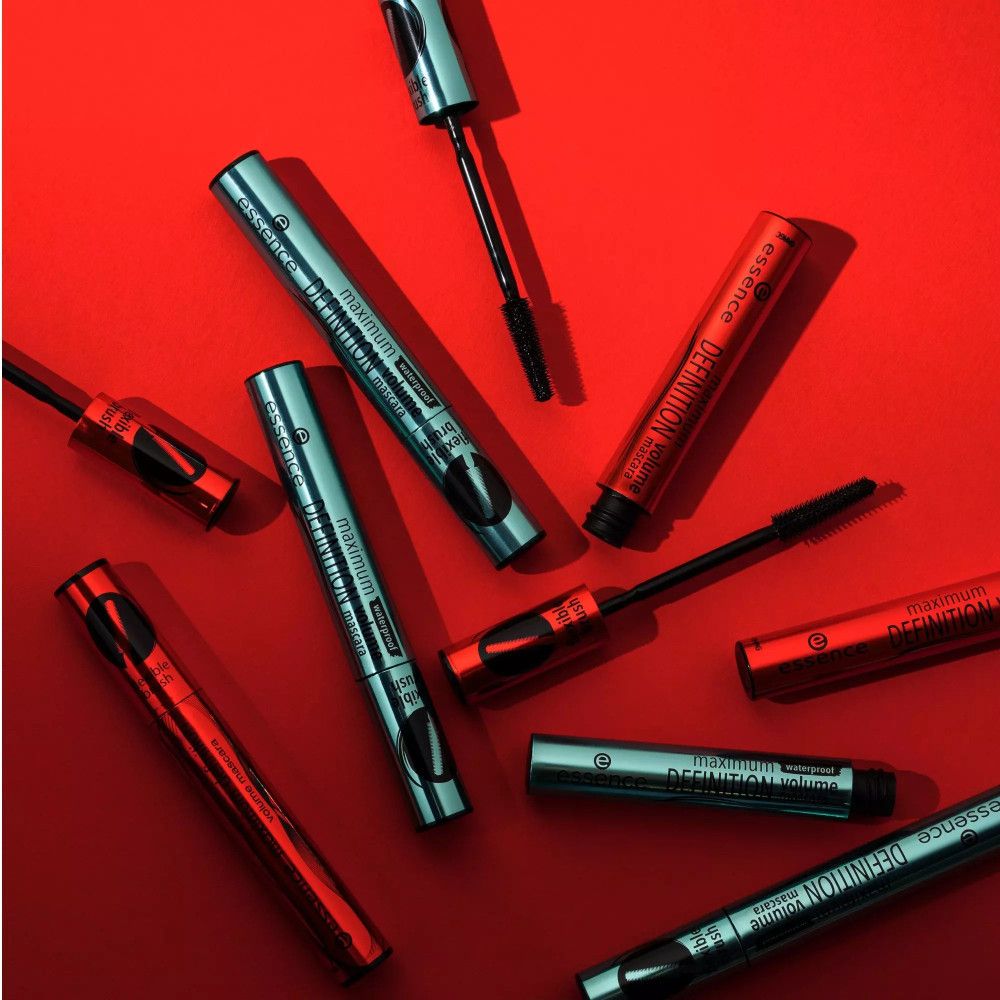 Plusieurs mascaras sur fond rouge. Certains sont ouverts, d'autres fermés. Inscription : Maximum Definition Volume Mascara.