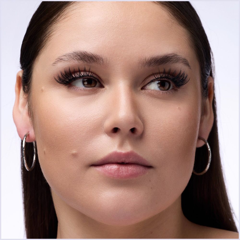 Close-up van een gezicht met wimperextensions. De ogen zijn open en kijken opzij.