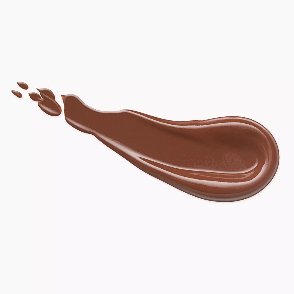 Trait de bronzer marron sur fond blanc. La texture est brillante et liquide.