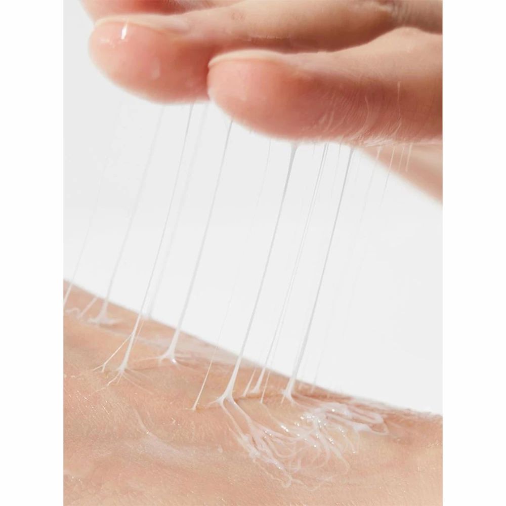 Close-up van hand die crème-draden op de huid aanbrengt. Witte crème.