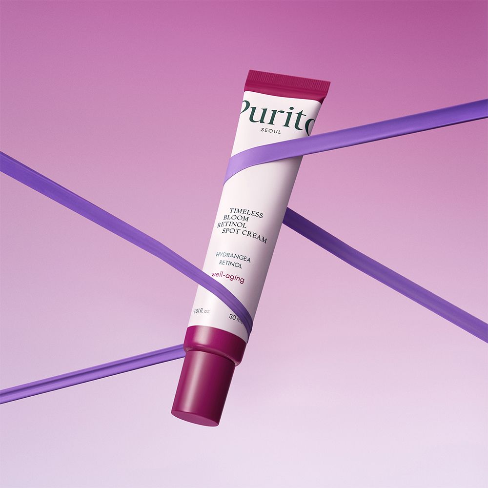 Tube de Purito Retinol Spot Cream enveloppée de ruban violet.
