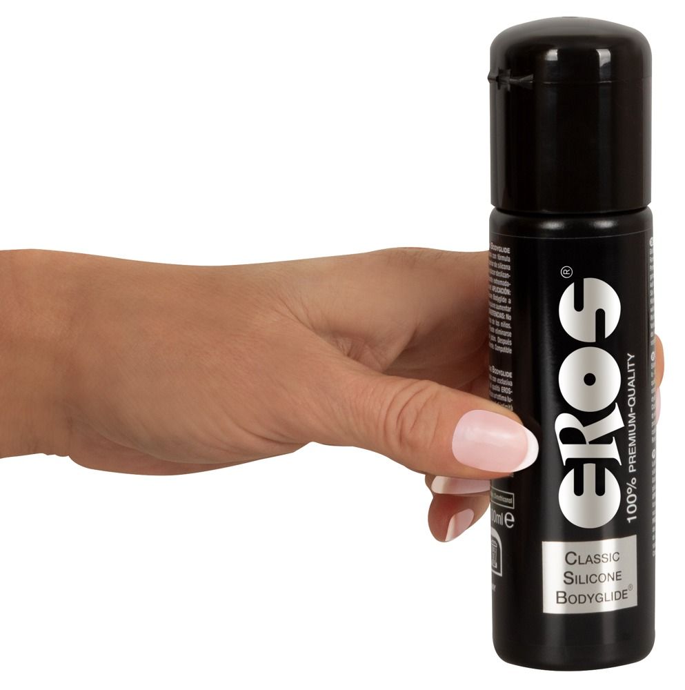 Hand die een zwarte fles Eros Bodyglide Classic Silicone vasthoudt.