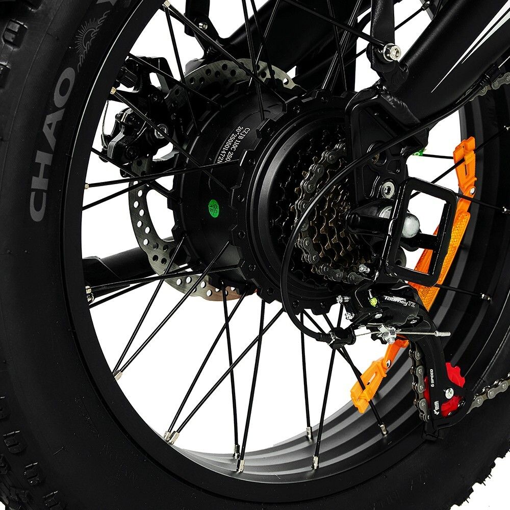 Gros plan sur la roue arrière d'un vélo électrique. Moteur, dérailleur et frein à disque visibles. Pneus noirs.