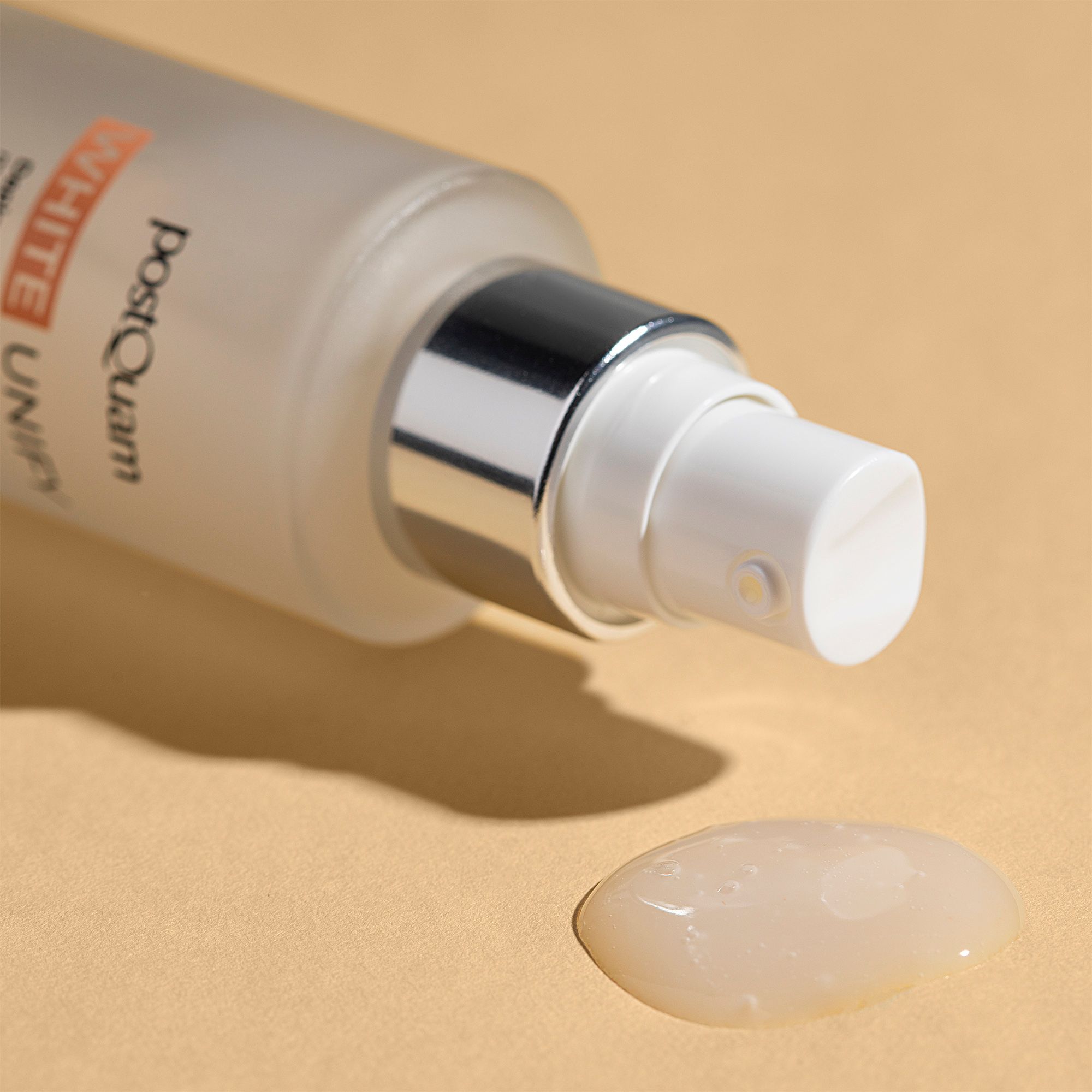 Flacon de sérum avec vaporisateur et goutte de sérum. Inscription : PostQuam, White Unify. Le sérum est incolore.