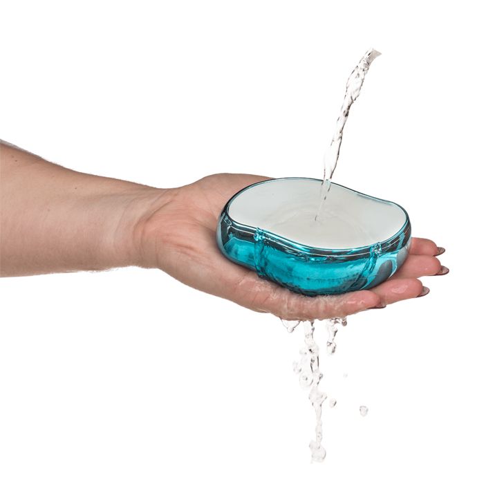 Épilateur ovale bleu dans une main, de l'eau est versée dessus.