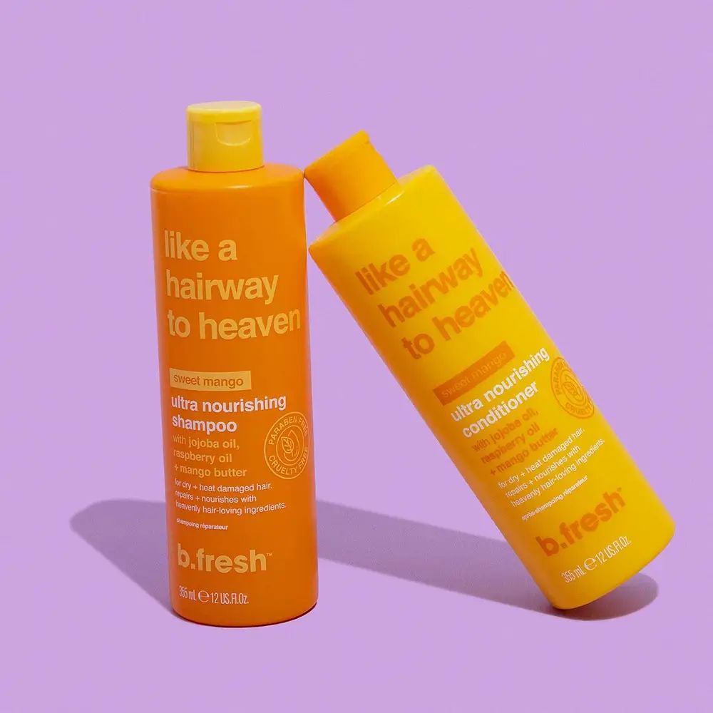 Twee flessen "Like a Hairway to Heaven". Oranje shampoo en gele conditioner. Ingrediënten en merk: b.fresh.